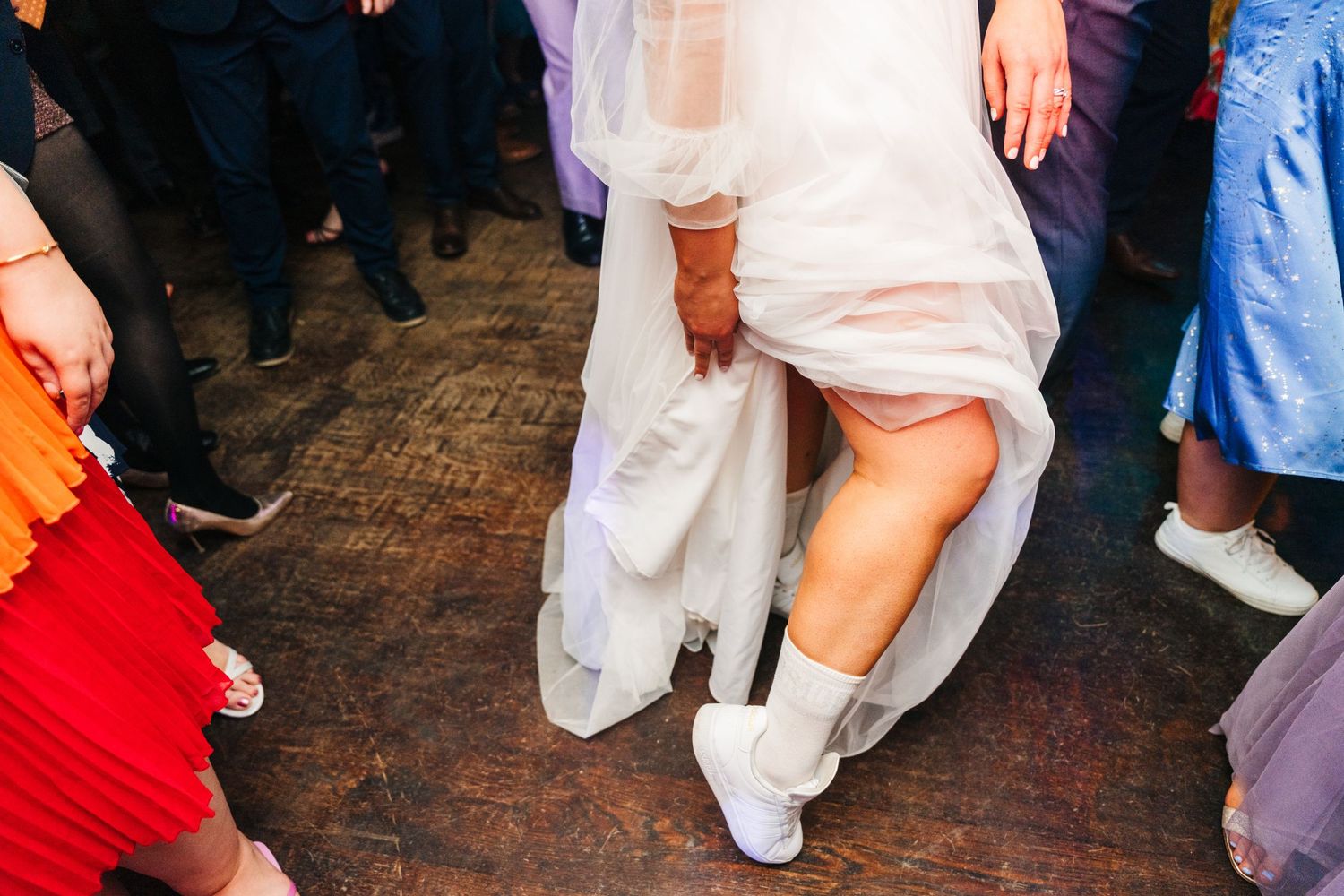 Millhouse slane wedding photographer dublin Wedding party dancing on a brick patio outdoors with hands raised in celebration.