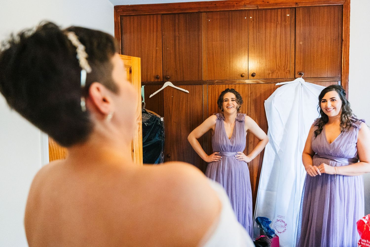 Millhouse slane wedding photographer dublin Purple bridesmaid dresses hang in a wood-paneled dressing room during wedding preparations.