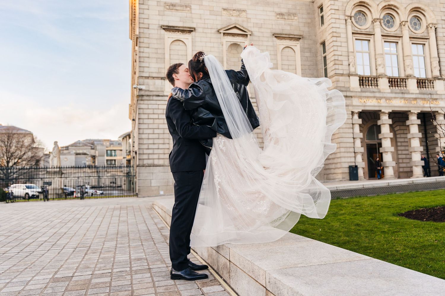 A dramatic wedding photo with flowing veil against classical architecture backdrop. Wedding PHOTOGRAPHER Dublin