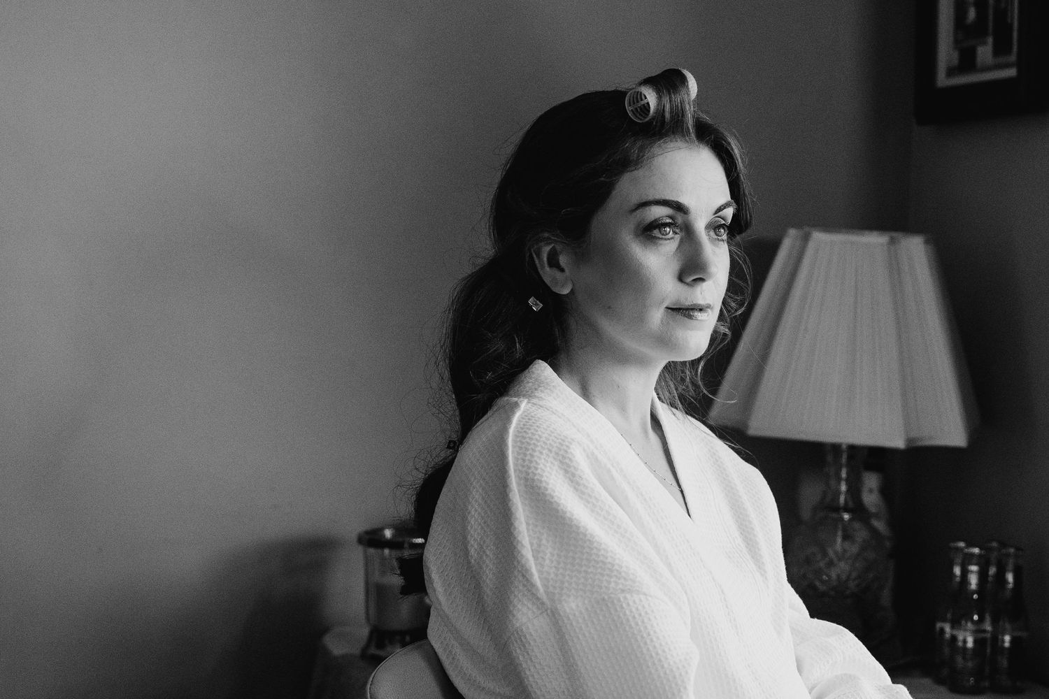Vintage black and white photograph of figure in white robe sitting near lamp in dramatic lighting. Castle Leslie Wedding Photographer Dublin