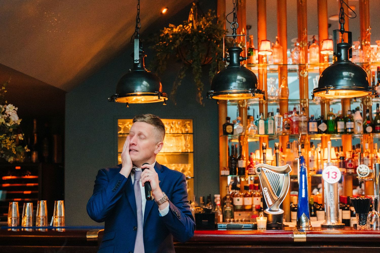 Warm ambient lighting illuminates a bar setting during an evening celebration. Marco Pierre Dublin Wedding Photographer