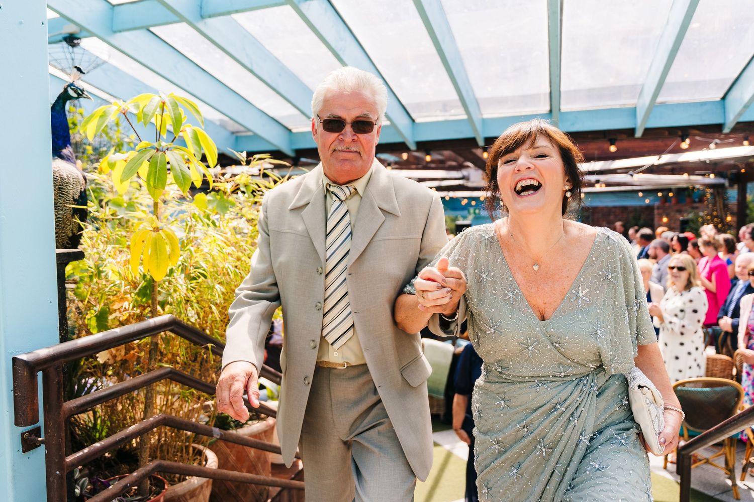 Candid moments of laughter shared under a bright glass-roofed venue. House Dublin Wedding Photographer