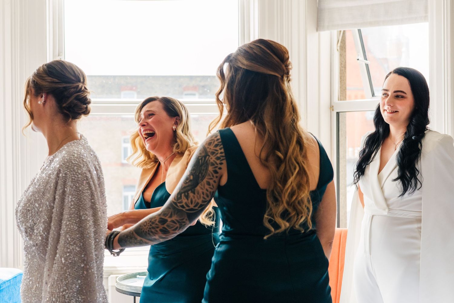 Series of candid pre-wedding moments showing bridesmaids in teal dresses and grey sweaters gathered by window light. House Dublin Wedding Ph