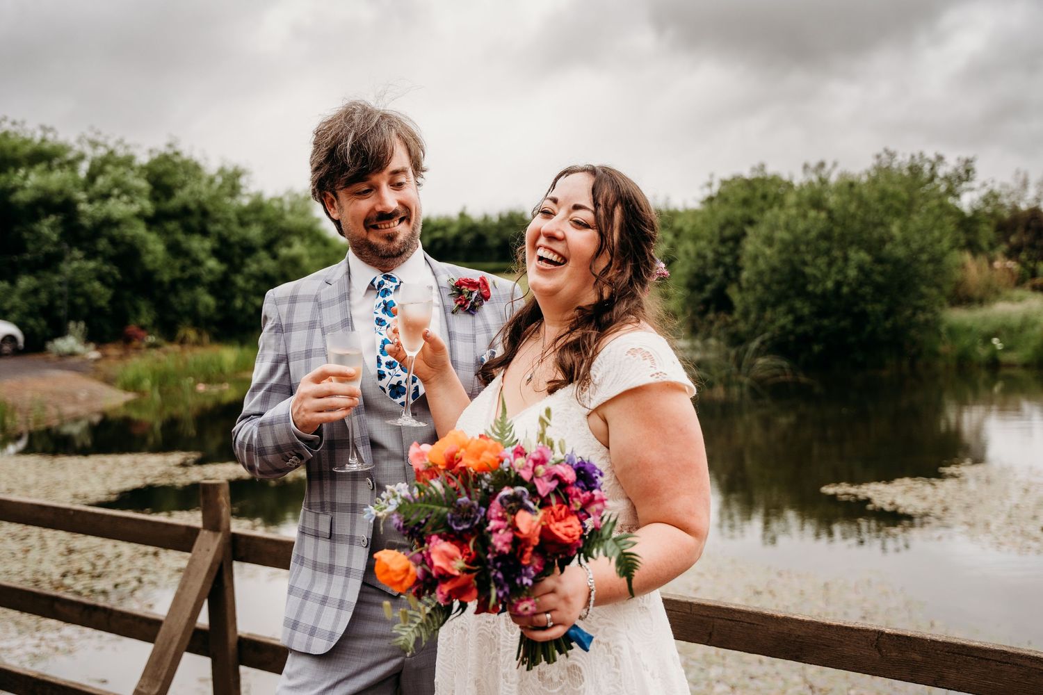 Candid wedding photos by a lake showing joyful moments and laughter. Wedding photographer Dublin