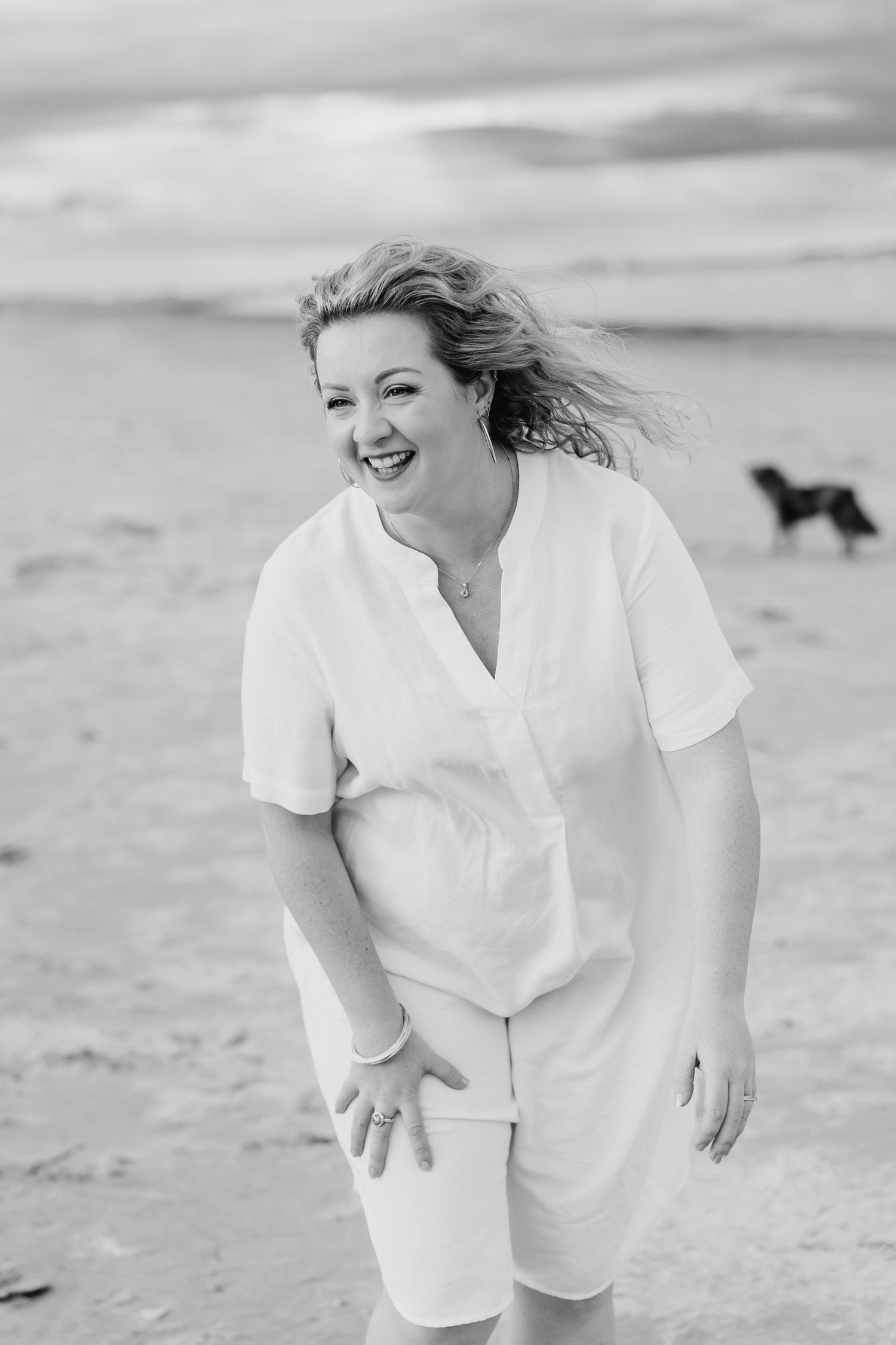 A person in white clothing runs joyfully along the beach on a cloudy day. PHOTOGRAPHER Dublin