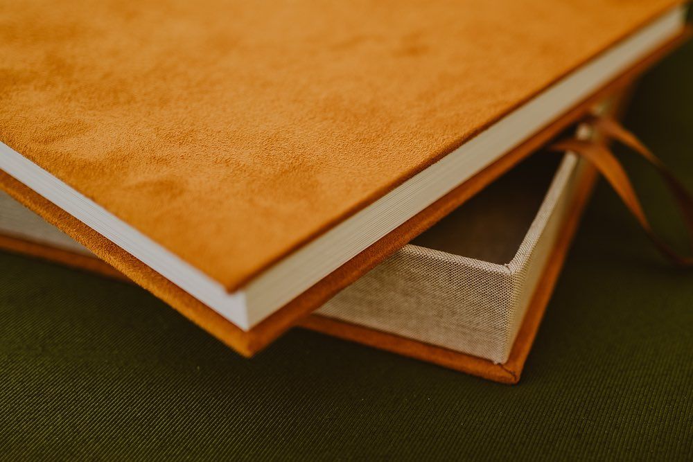 Stack of vintage leather-bound books with worn pages arranged in a warm, golden-lit setting.