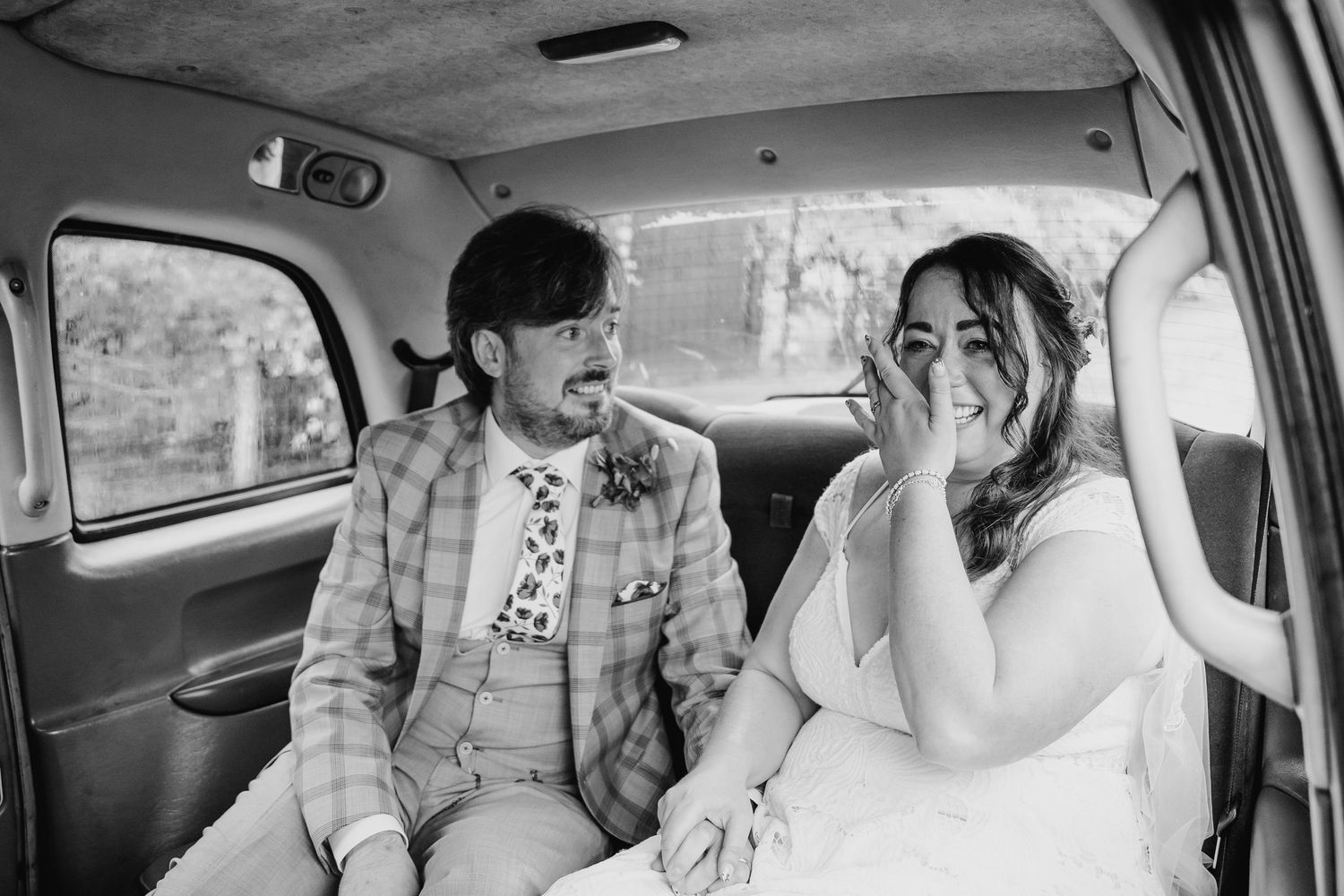 Black and white candid shots of people laughing together inside a car. Wedding photographer Dublin