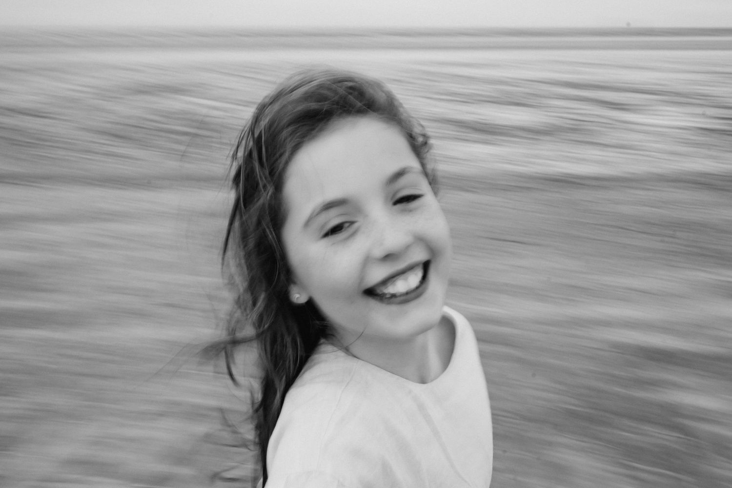 Black and white motion portrait of a happy person against a blurred background.  Family photographer Dublin Ireland