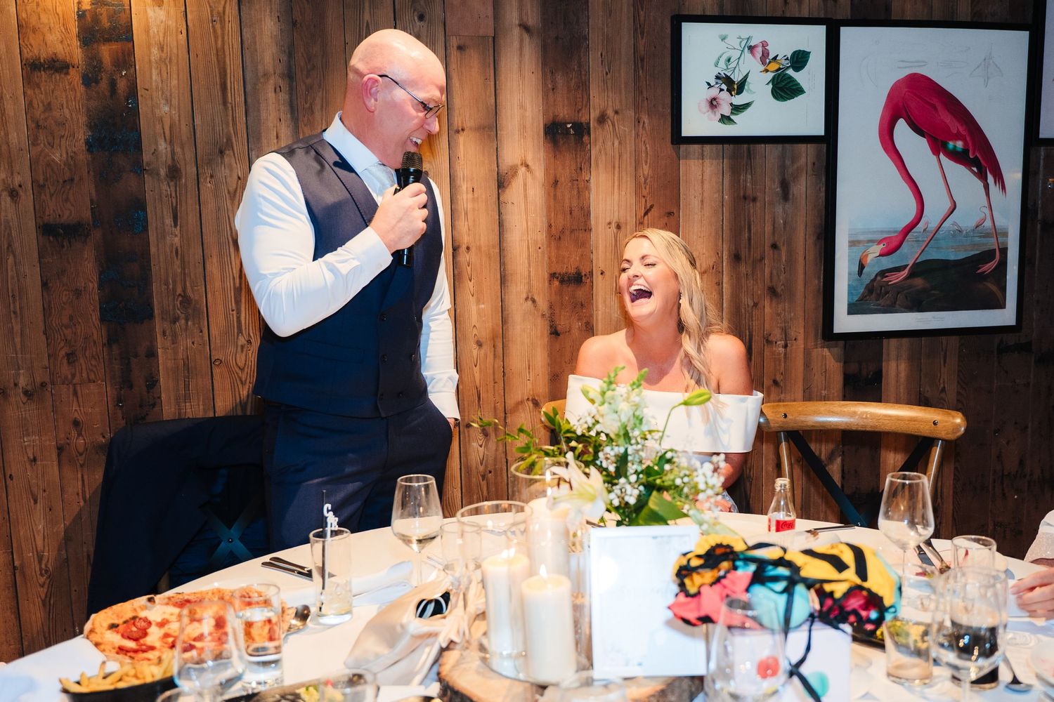 A wedding reception scene with decor and laughter at a rustic wooden venue. The Dean Dublin Wedding Photographer