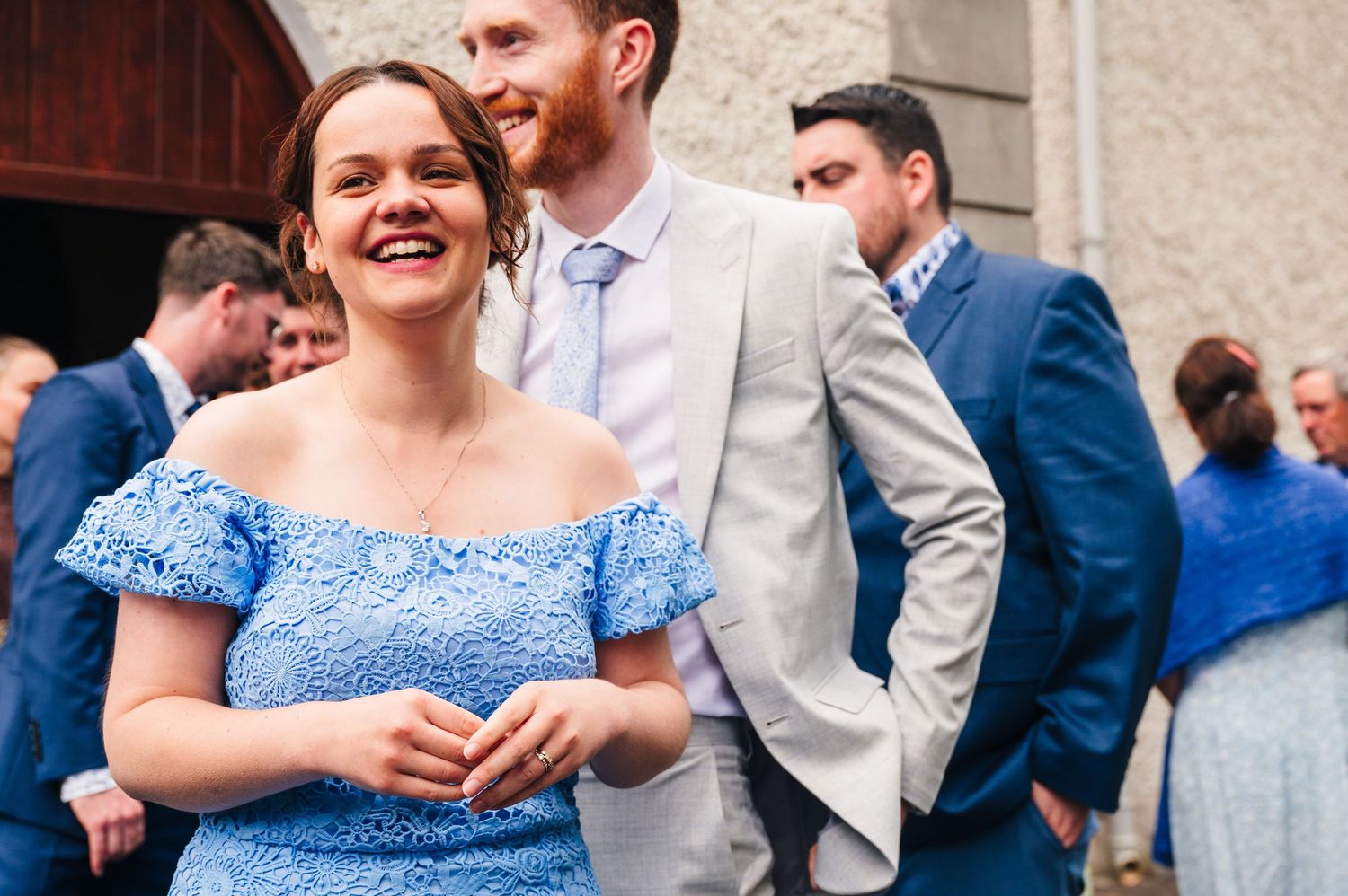 Millhouse slane wedding photographer dublin Wedding guests in blue dresses socialize at an outdoor reception.
