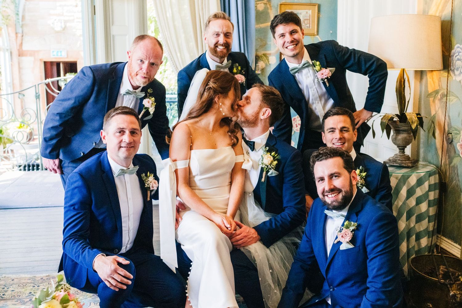 Castle Leslie Wedding Photographer Dublin Wedding party in navy suits posing together for fun group photo with newlyweds.