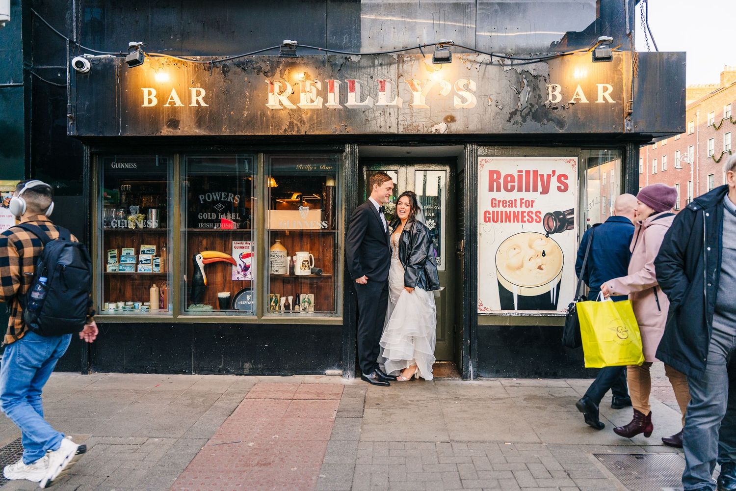 Wedding couple posing outside Reilly's Bar in casual urban setting. Wedding PHOTOGRAPHER Dublin