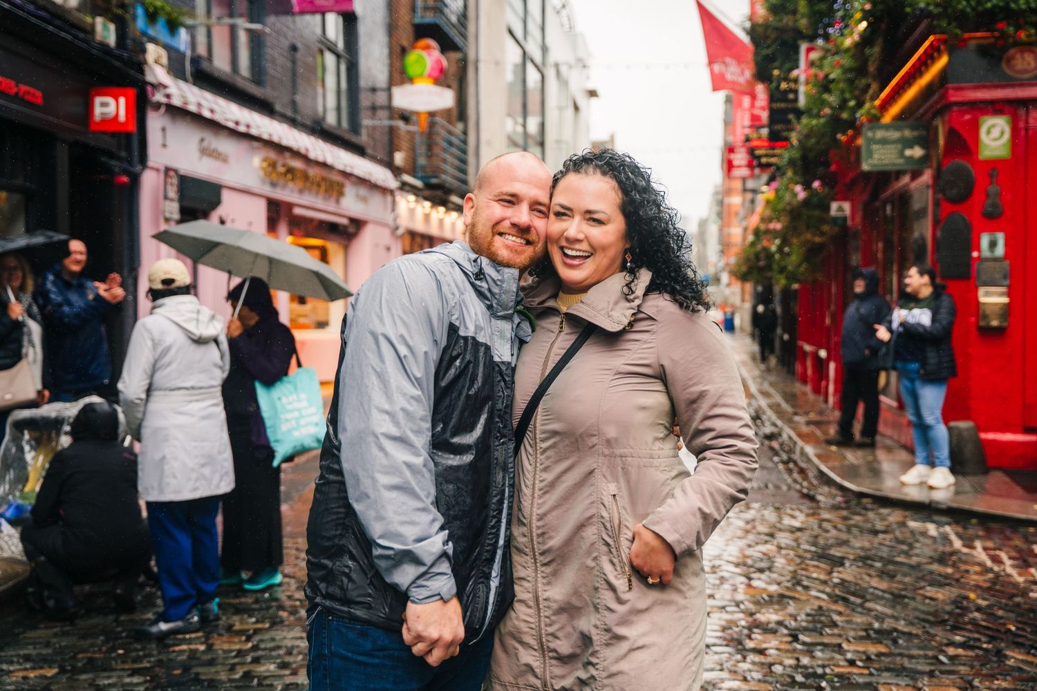 Two tourists explore the charming cobblestone Temple Bar district in Dublin on a rainy afternoon. Proposal Dublin Photographer
