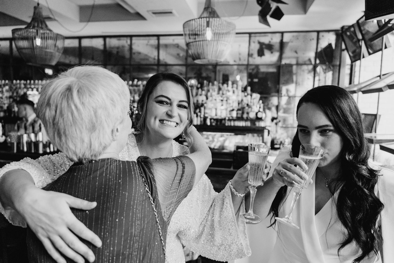 Friends share emotional embraces and moments at an indoor celebration. House Dublin Wedding Photographer
