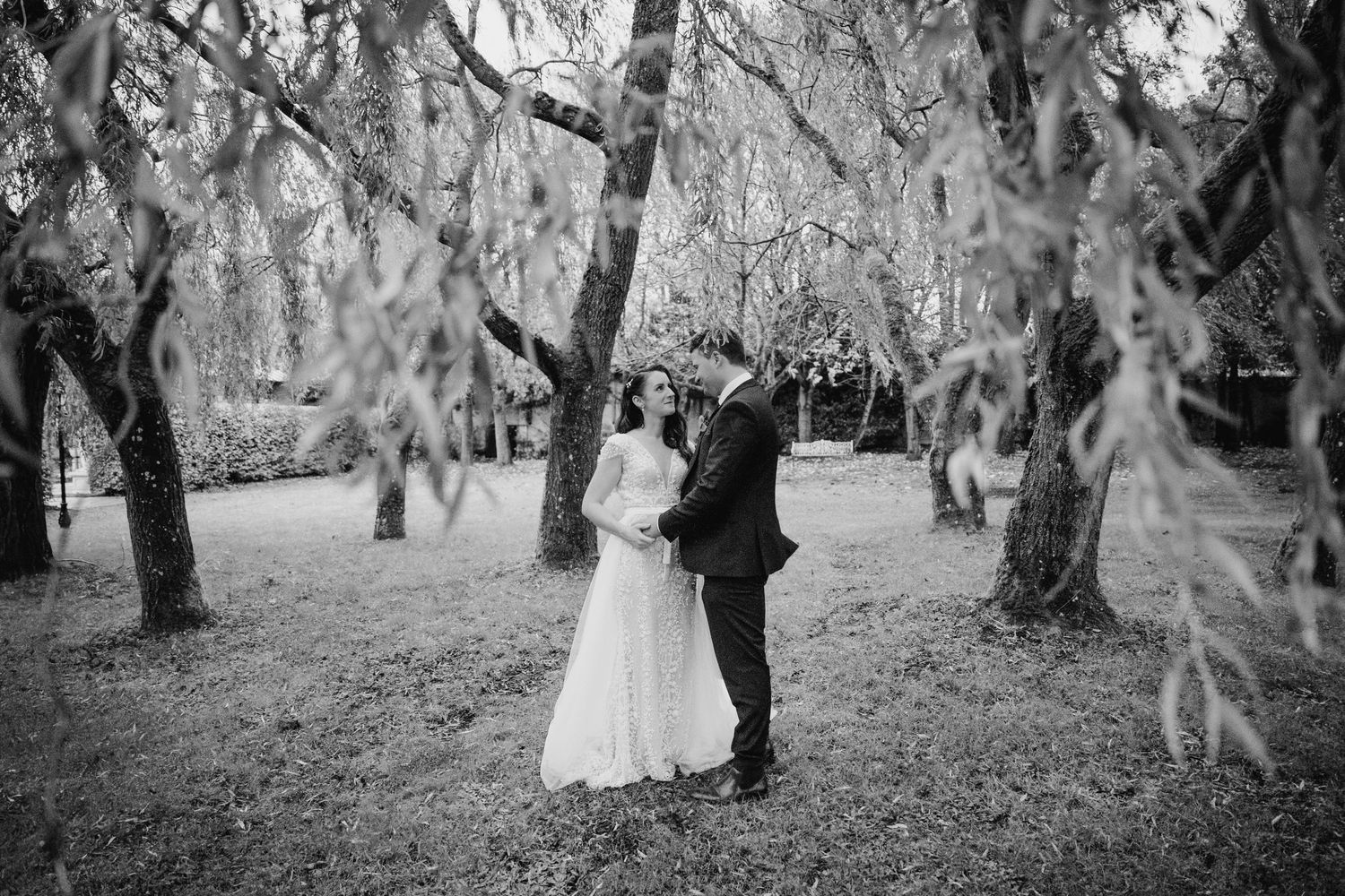 Black and white photos of couple walking through a mystical forest with hanging moss.