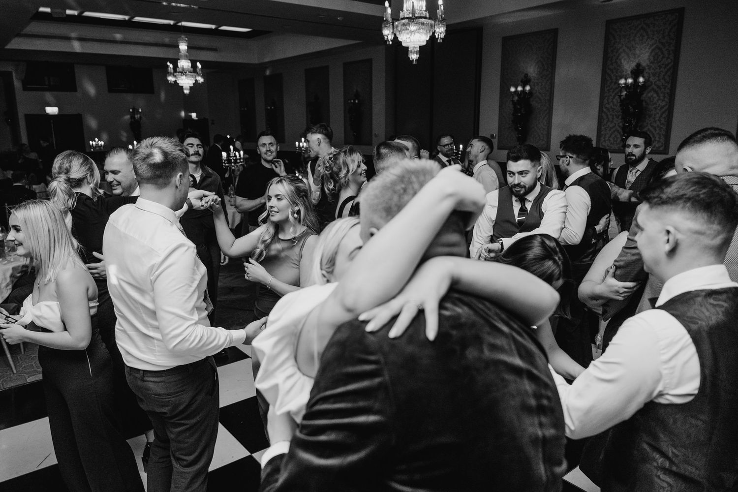 Black and white photo of wedding guests dancing energetically at the reception. Wedding photographer dublin