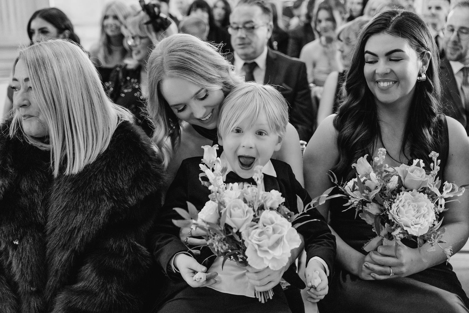 Black and white photo of wedding guests laughing and reacting during an emotional moment. Wedding photographer dublin