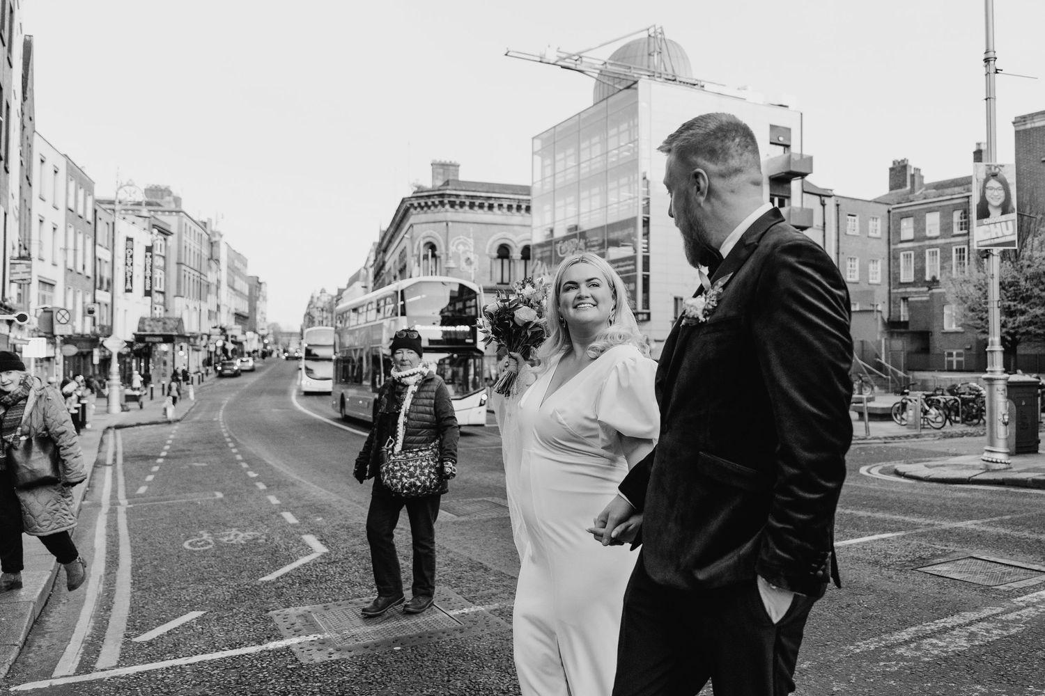 Black and white street scene with urban buildings and pedestrians. Wedding photographer dublin