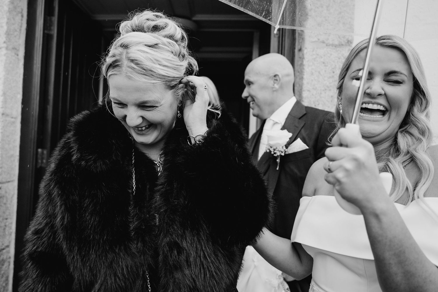 Group celebrating at wedding with joyful laughter in formal attire. The Dean Dublin Wedding Photographer