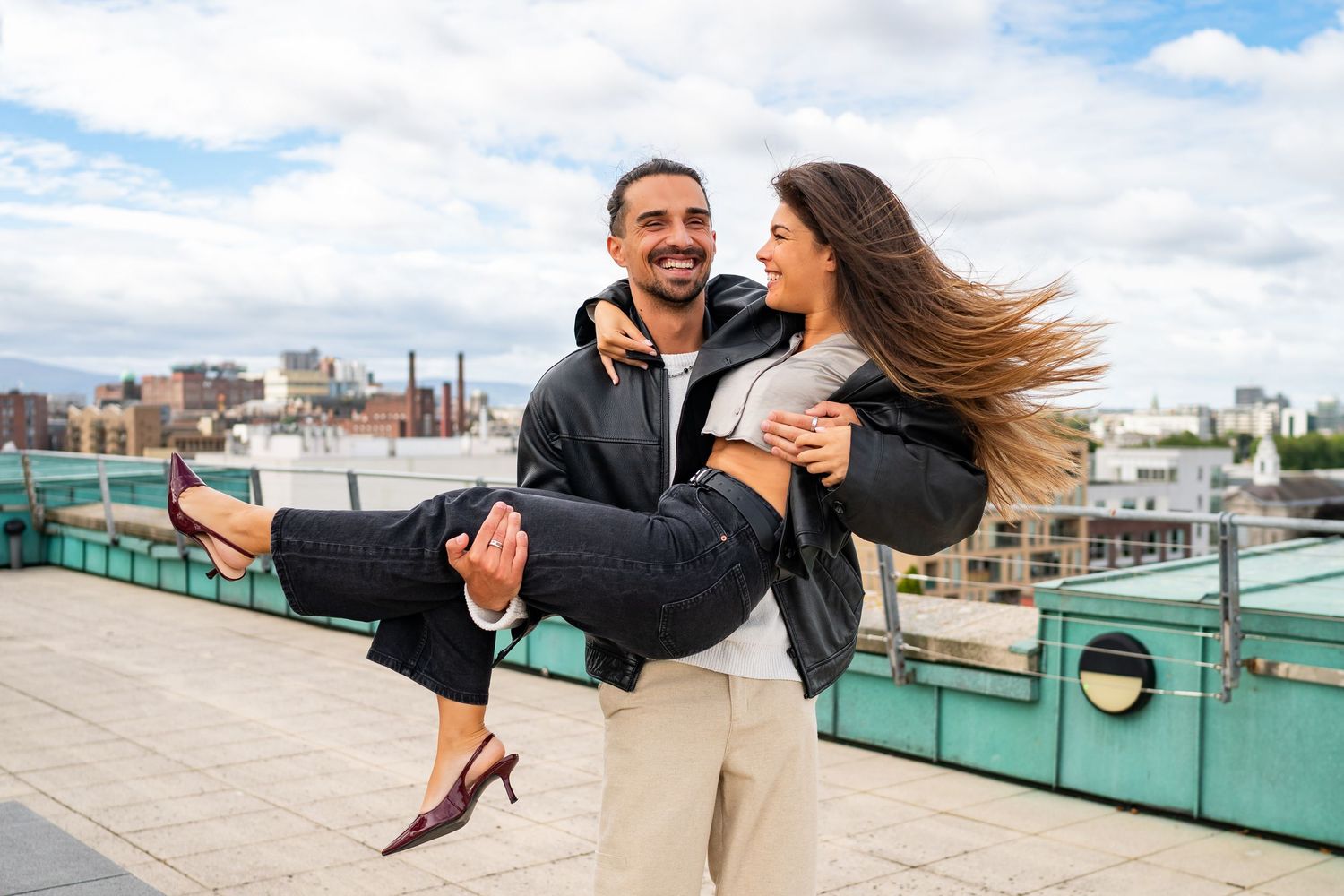 Couple dancing and twirling on rooftop terrace with urban skyline view. Couple's Photoshoot PHOTOGRAPHER Dublin