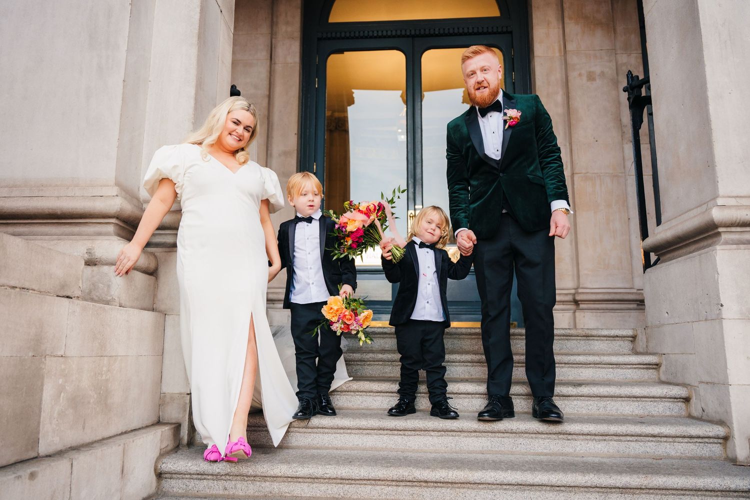 Wedding party posing on stone steps outside historic building. Wedding photographer dublin