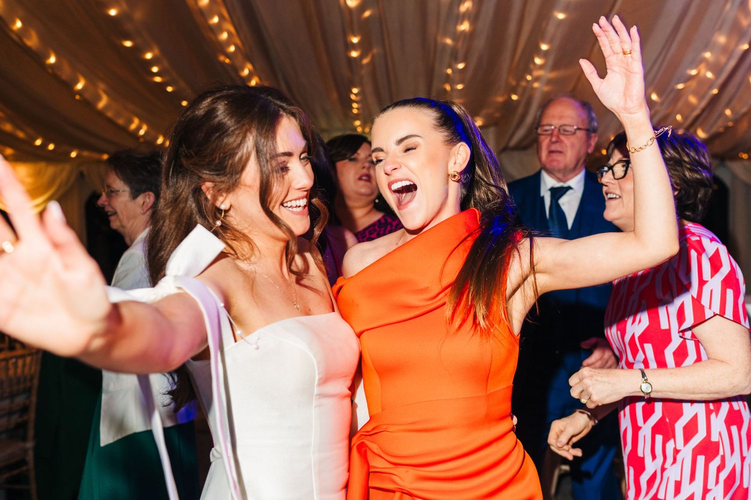 Castle Leslie Wedding Photographer Dublin Wedding guests dancing and celebrating with high energy under string lights.