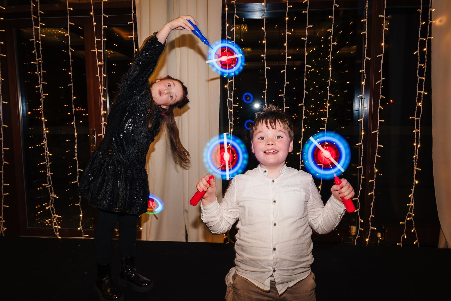 Wedding reception party with festive string light backdrop and dancing guests.  Wedding PHOTOGRAPHER Trim Castle