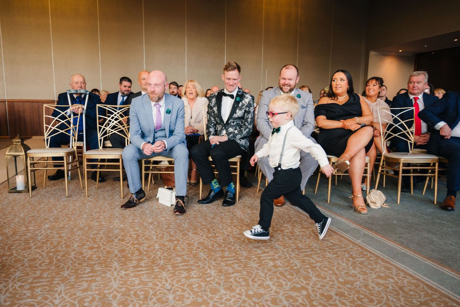 Wedding reception scene with guests seated in chairs while someone dances.  Wedding PHOTOGRAPHER Trim Castle