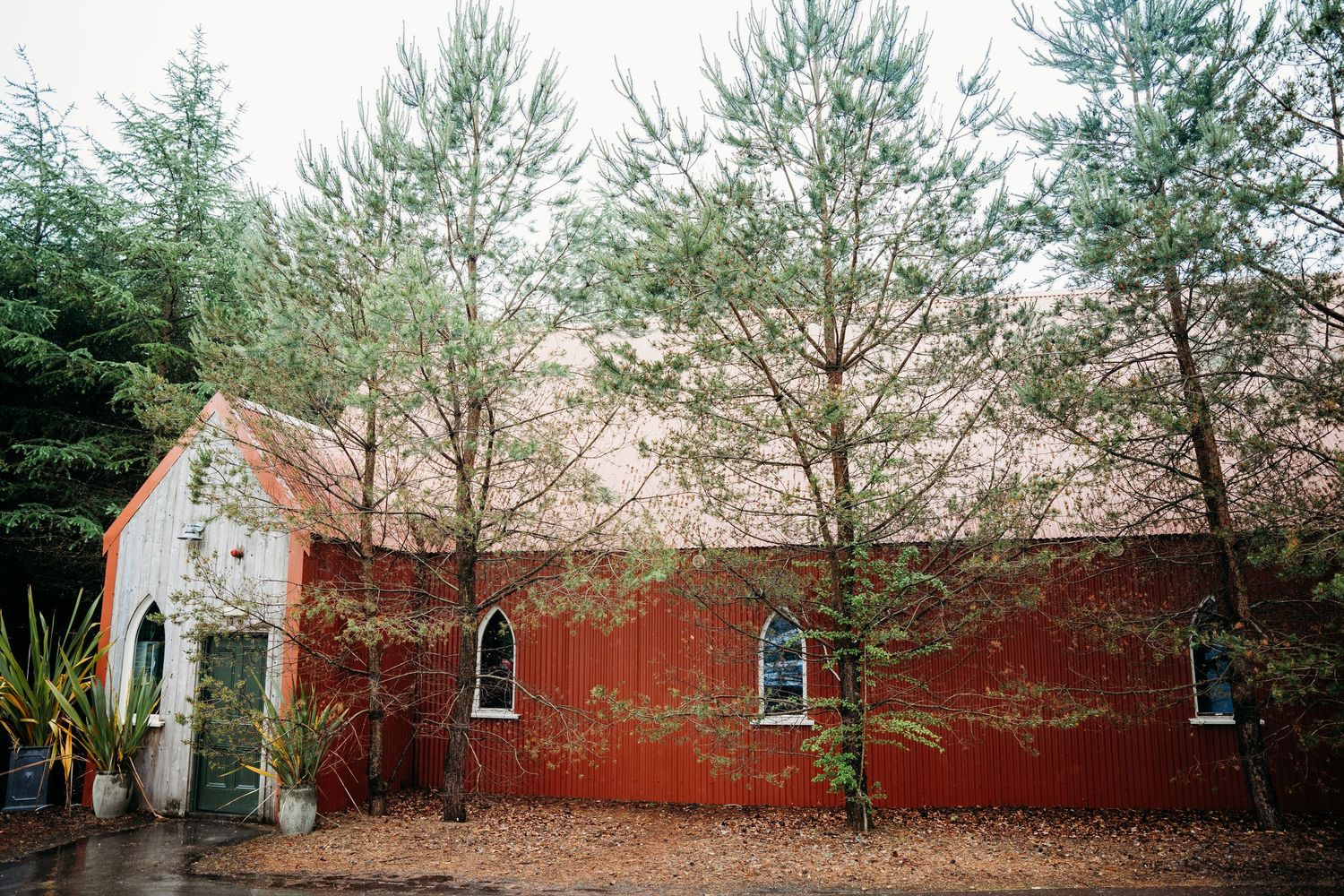 Long red brick building exterior with evergreen trees in natural setting. Wedding photographer Dublin