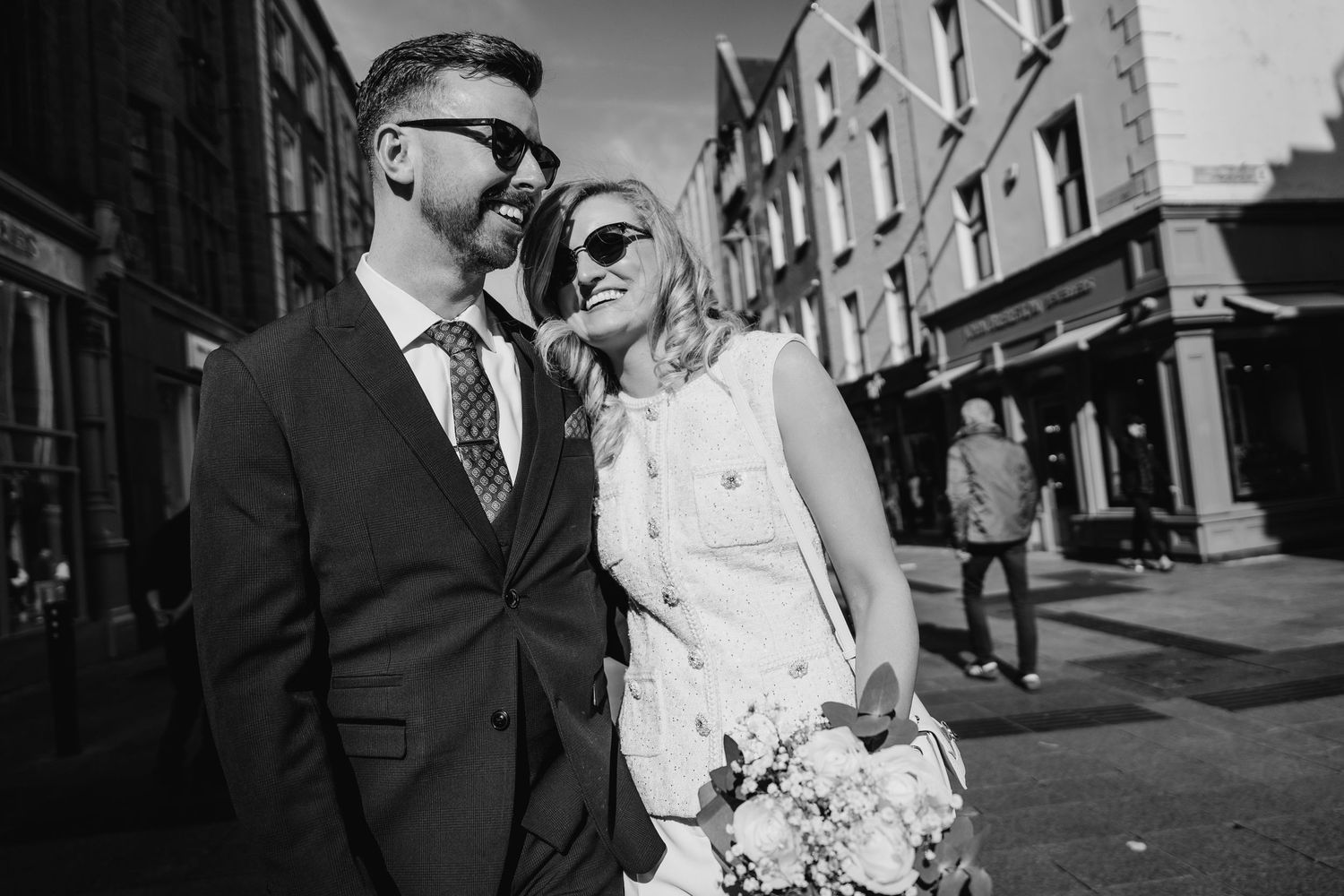 A newlywed couple poses together on a brick-lined city street. City Hall Dublin wedding photogrAPher