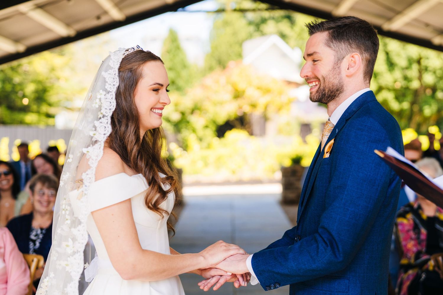 Outdoor wedding ceremony moment as couple exchanges vows surrounded by guests on a sunny day.Poulaphouca Wedding photographer wicklow
