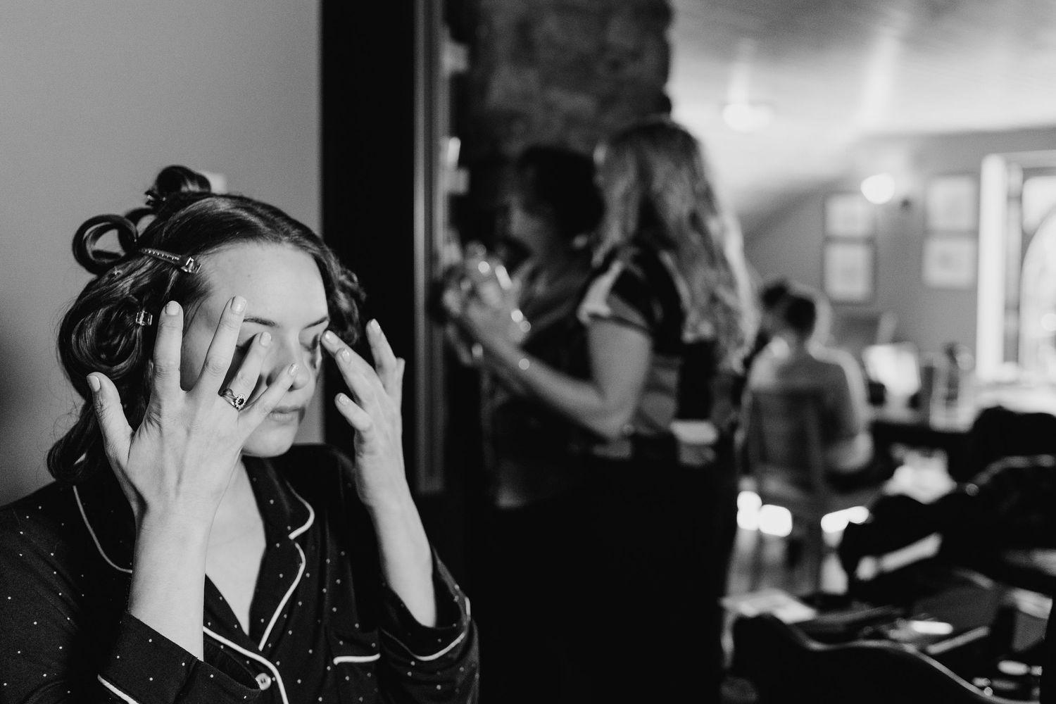 A person in curlers covers their face with their hands in this black and white candid moment. Poulaphouca Wedding photographer wicklow