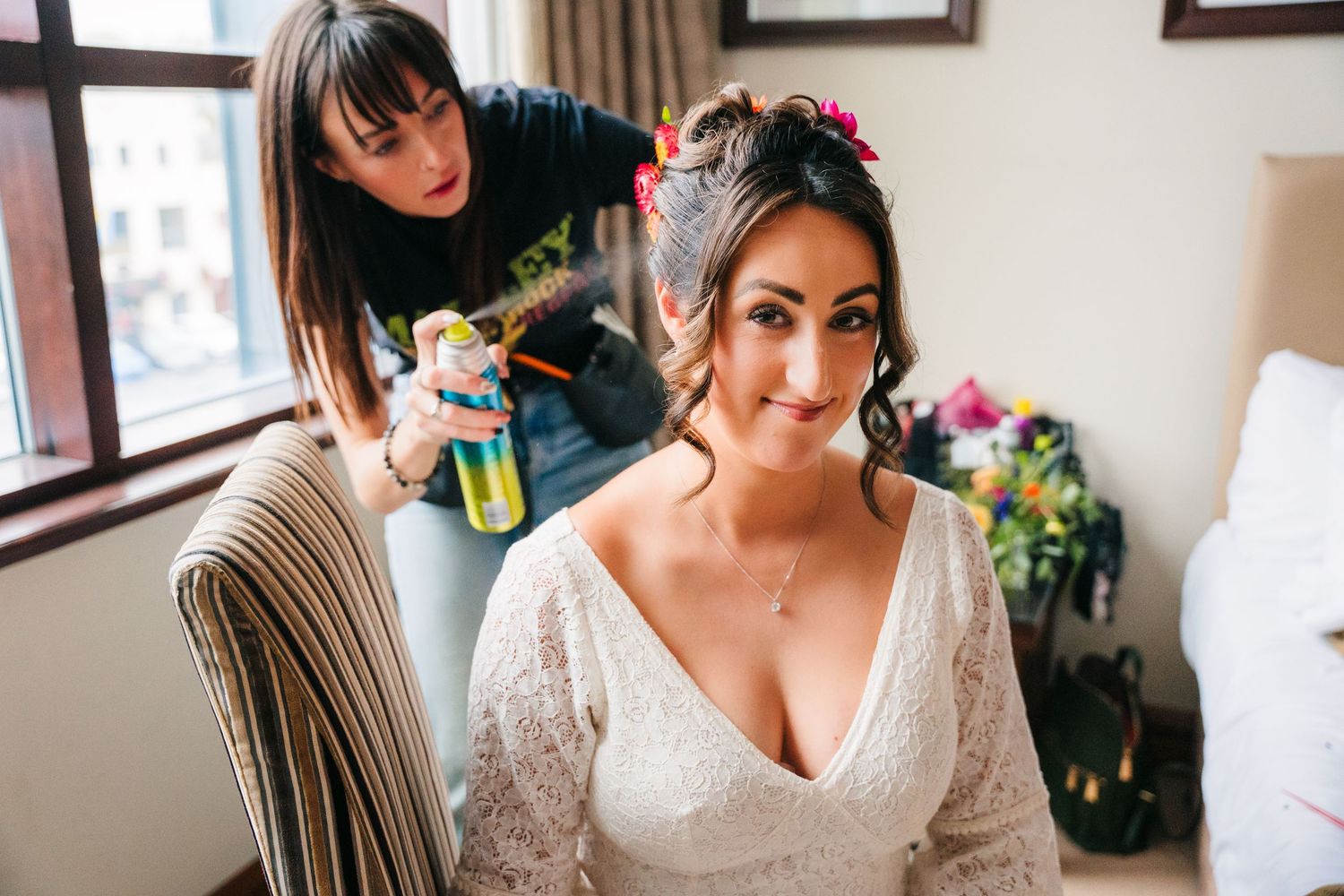 Woman getting ready on her wedding day wearing a white lace gown in an elegant room with framed artwork. Wedding Photography Trim Castle Ire