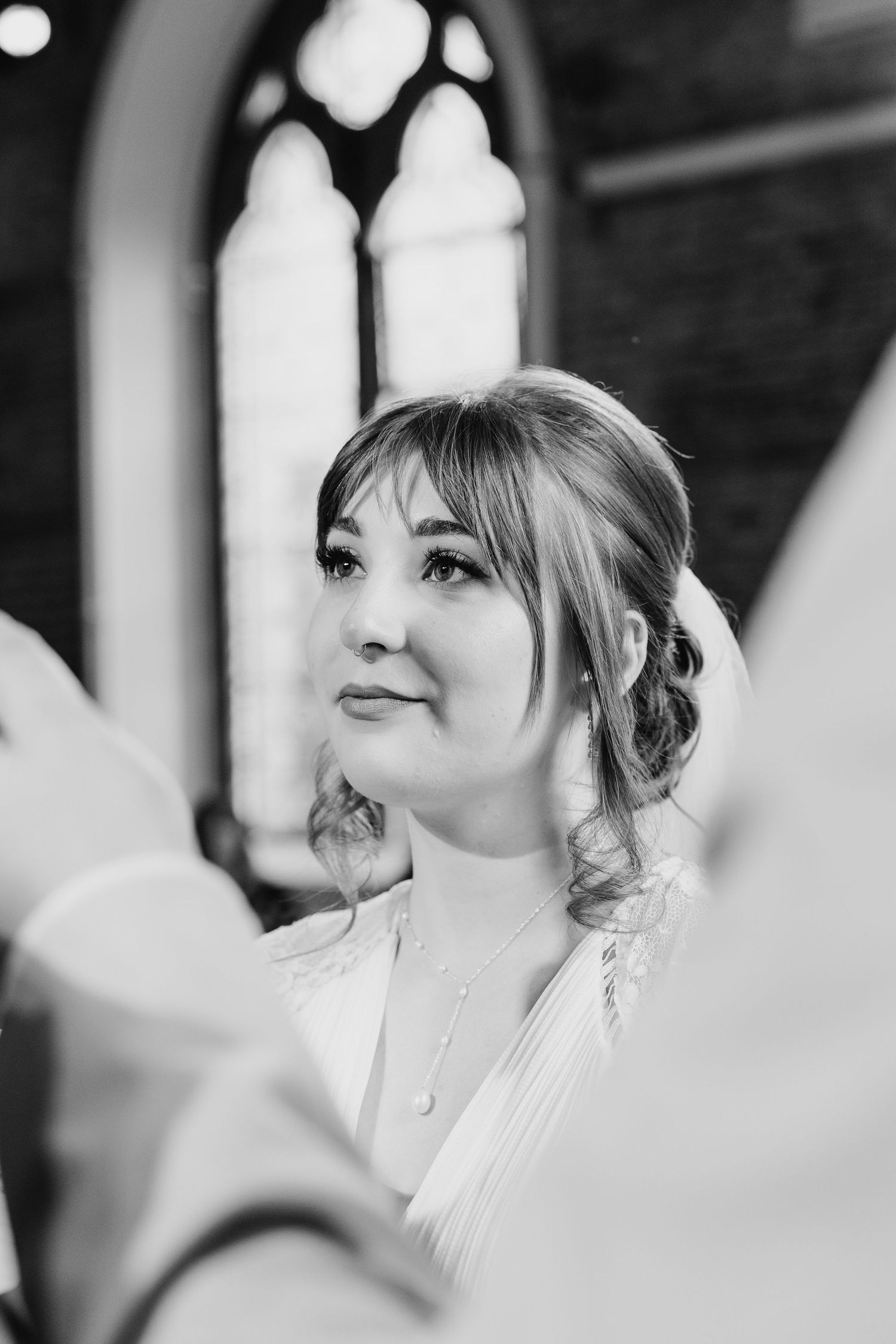 Black and white portrait inside chapel with gothic window in background. PHOTOGRAPHER Dublin Ireland Wedding