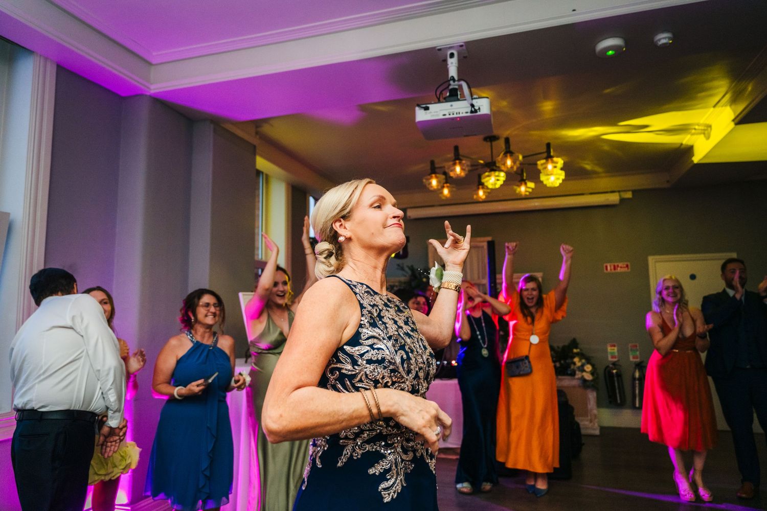 Wedding reception dance party with colorful lighting and guests enjoying the celebration. PHOTOGRAPHER Dublin Ireland Wedding