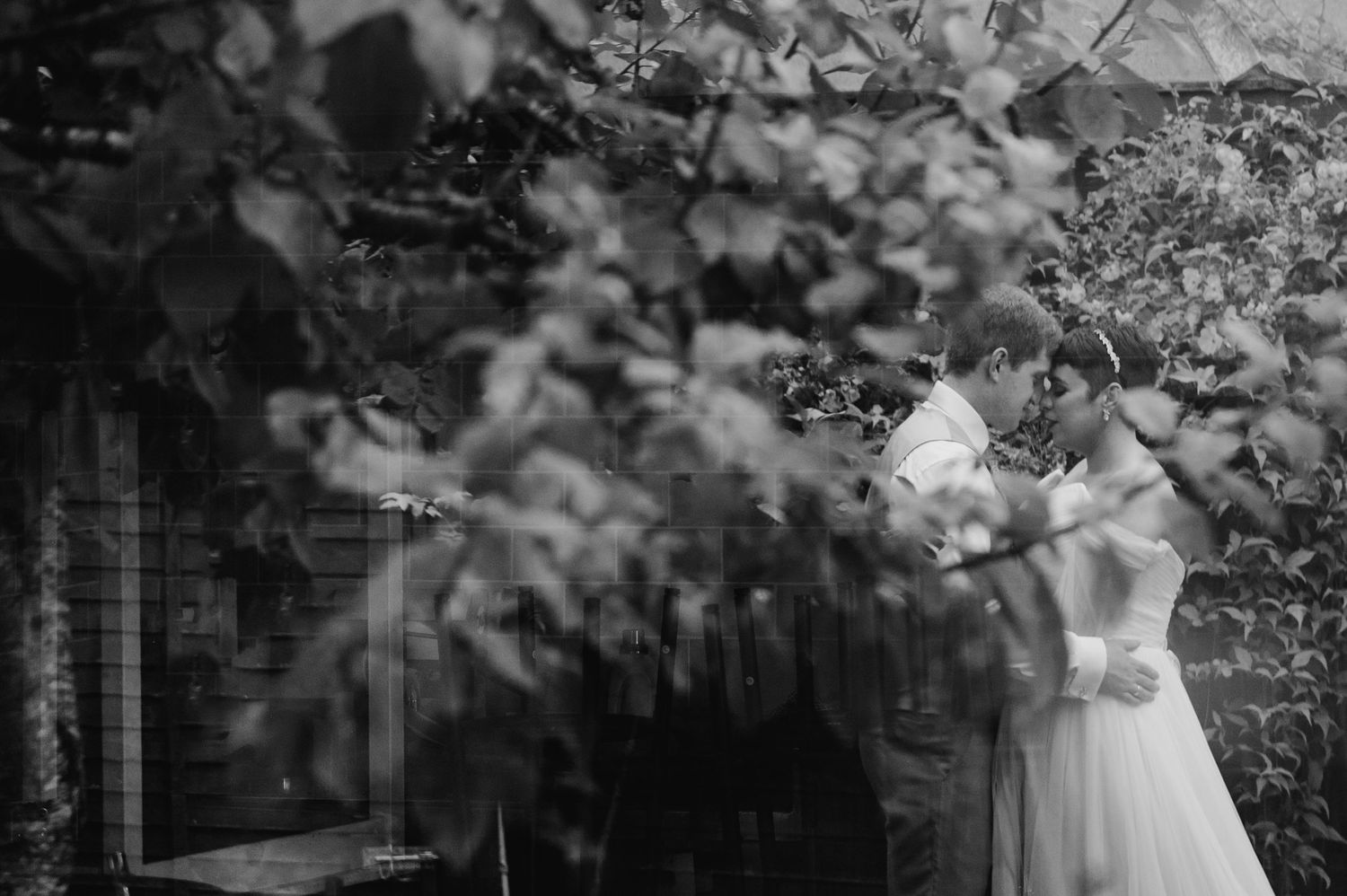 Millhouse slane wedding photographer dublin Artistic black and white wedding photography through foliage creating natural framing effect.