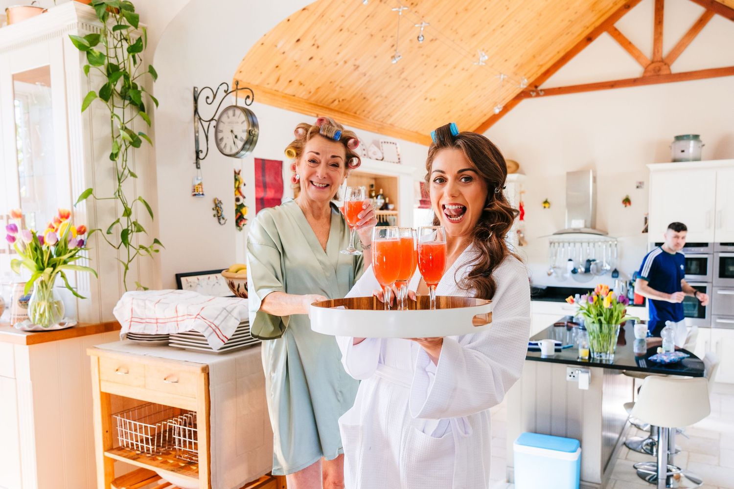Castle Leslie Wedding Photographer Dublin  Two people in a bright kitchen hold serving trays with drinks and snacks.