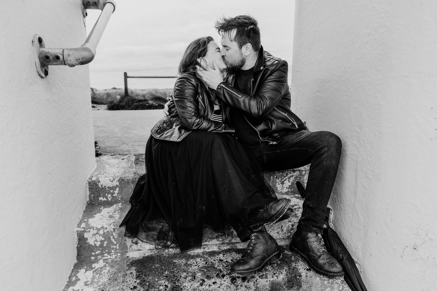 Intimate black and white photo series of couple lounging against white wall. engagement PHOTOGRAPHER Dublin