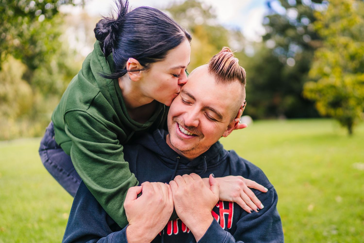 Candid outdoor embrace in a sunny park setting. PHOTOGRAPHER Dublin Ireland