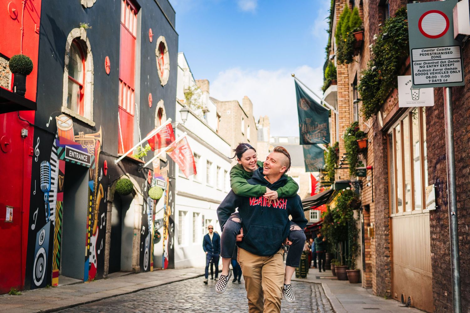 Couple sharing a playful moment on a cobblestone street in Dublin's historic district. PHOTOGRAPHER Dublin Ireland
