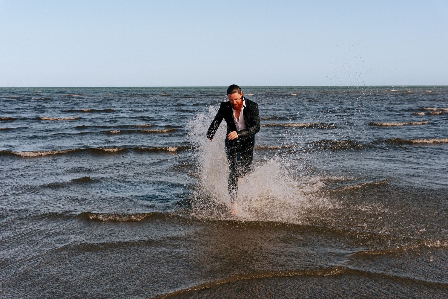 Person splashing and running through shallow ocean water creating dramatic spray patterns. PHOTOGRAPHER Dublin