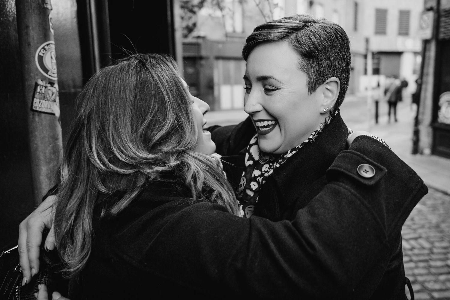 Black and white photo of a couple sharing a tender moment outdoors. Family walking through Dublin city centre during a relaxed vacation phot