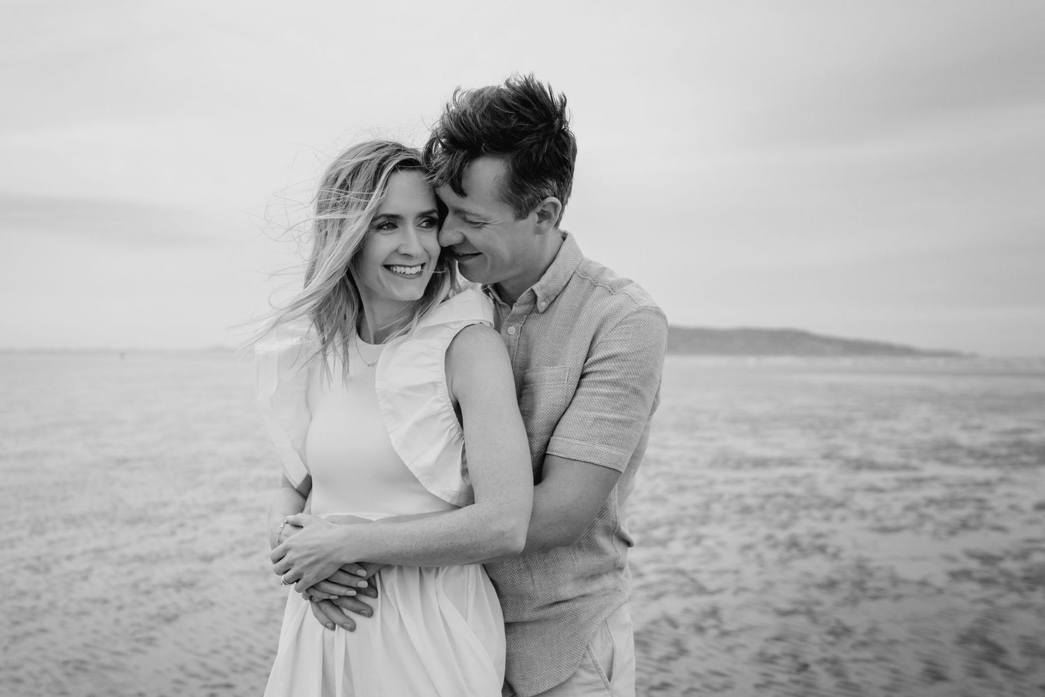 A series of intimate black and white beach photographs showing tender moments against a coastal backdrop.  Family photographer Dublin Irelan