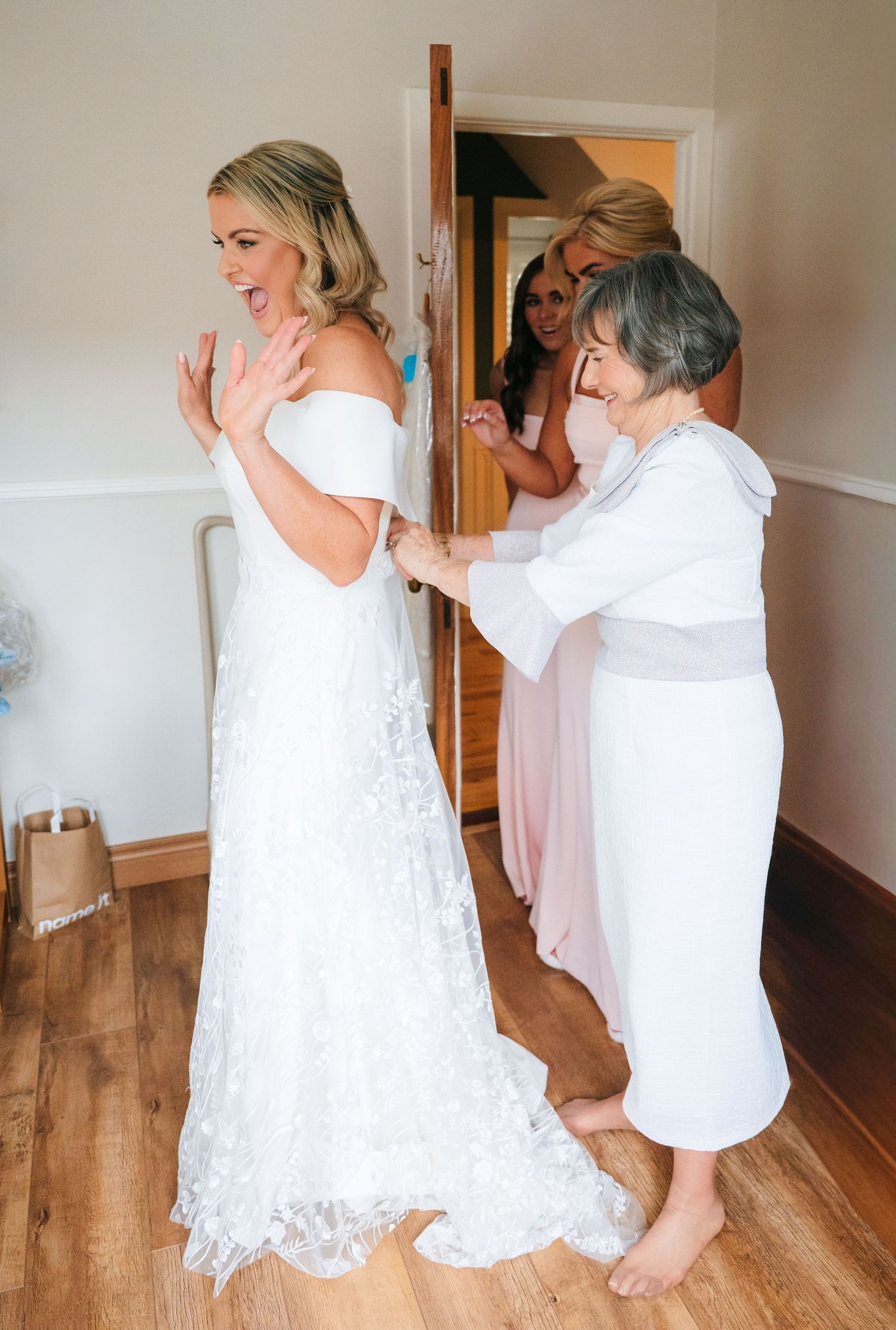 A sequence of joyful moments captured in white dresses against a wooden floor background during a wedding preparation. The Dean Dublin Weddi