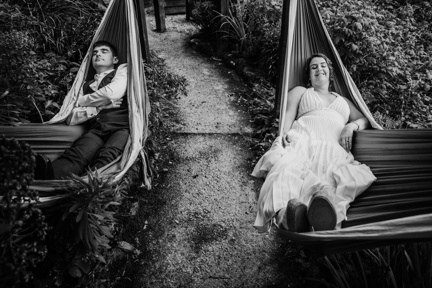 Black and white artistic wedding photo showing couple relaxing separately in hammocks along a garden path. Wedding PHOTOGRAPHER Dublin