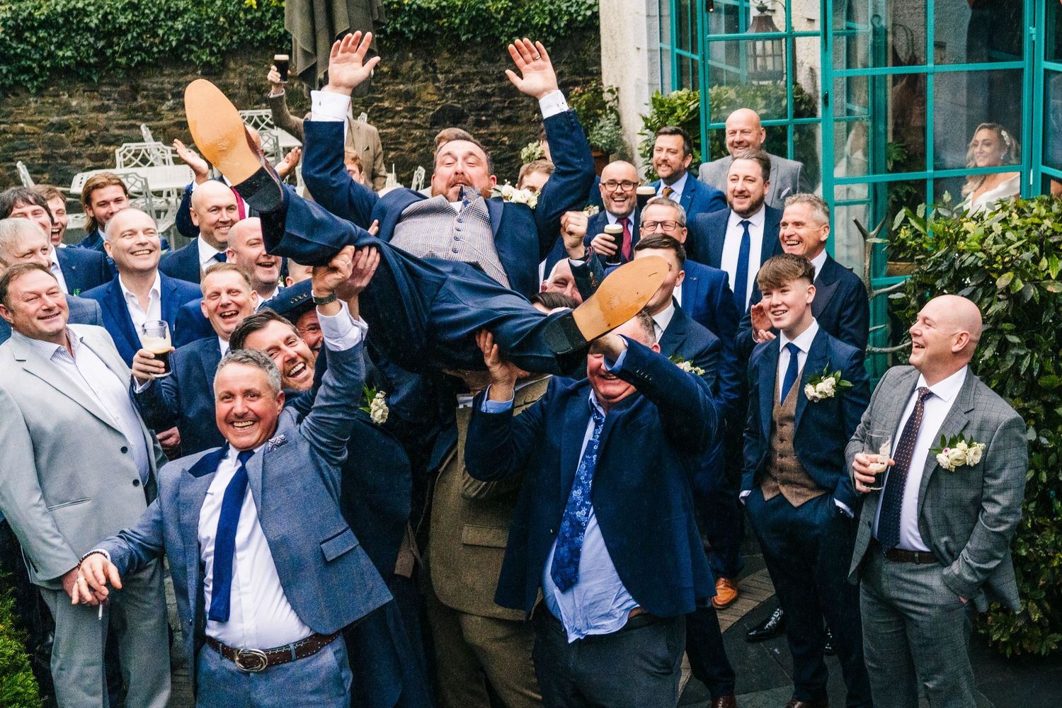 Groomsmen lifting someone in celebration during outdoor wedding photography.  Virginia Park Lodge Wedding Photographer Cavan Dublin Ireland