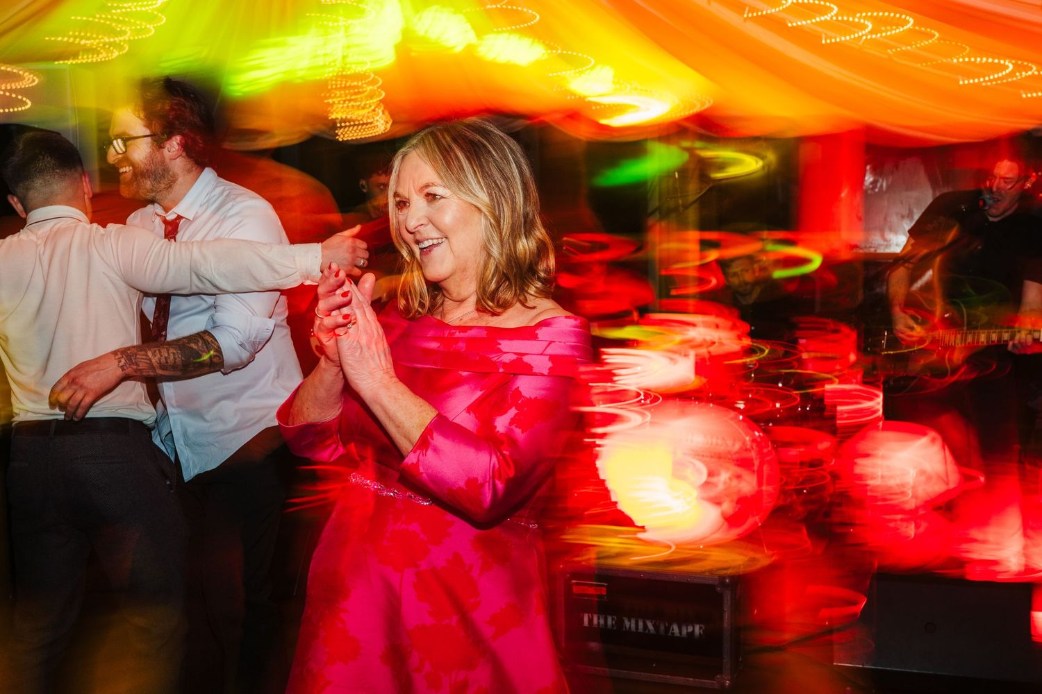 Wedding dance floor illuminated with vibrant red and yellow lighting effects.  Virginia Park Lodge Wedding Photographer Cavan Dublin Ireland