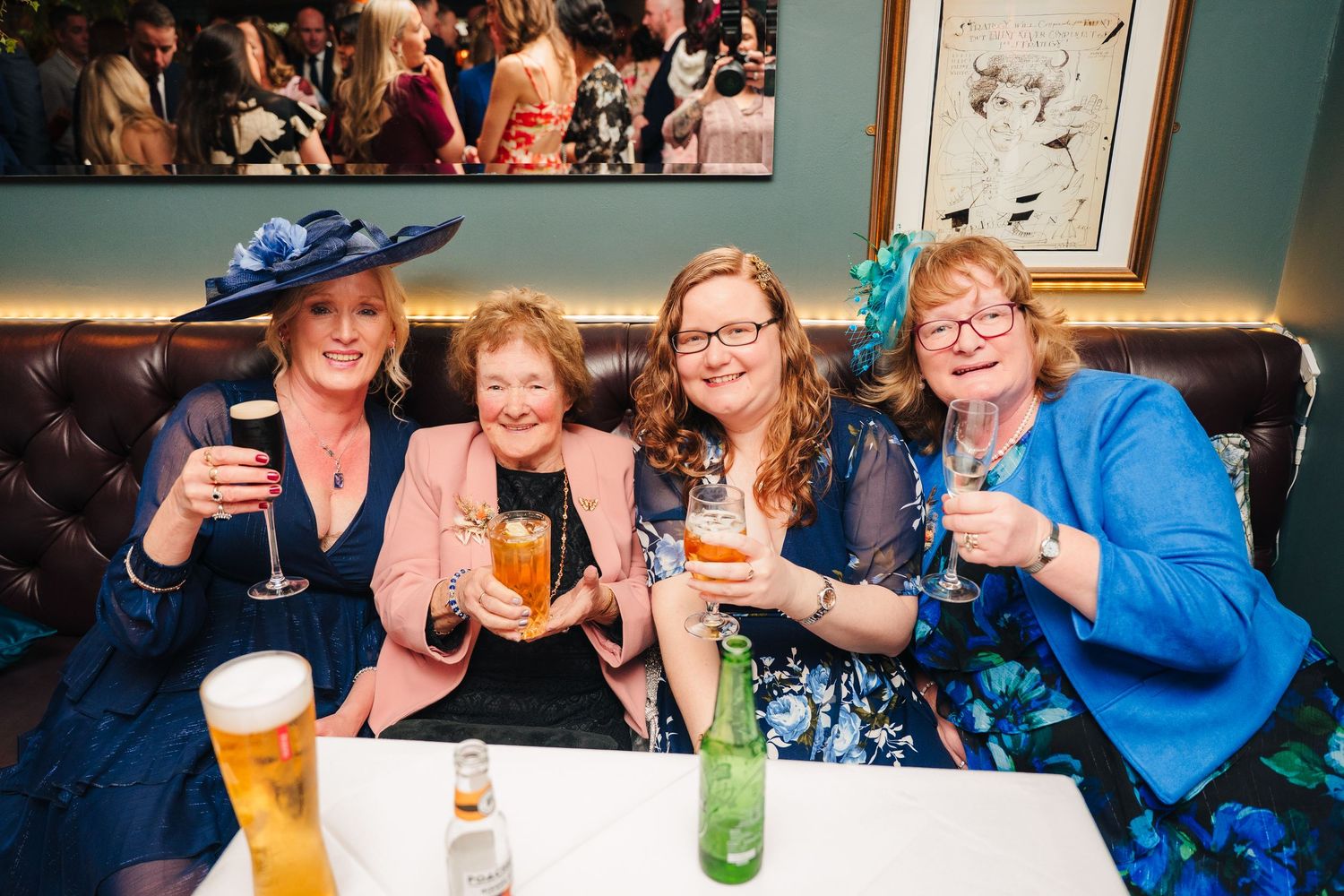 Group enjoying drinks and conversation at social gathering around table. Marco Pierre Dublin Wedding Photographer