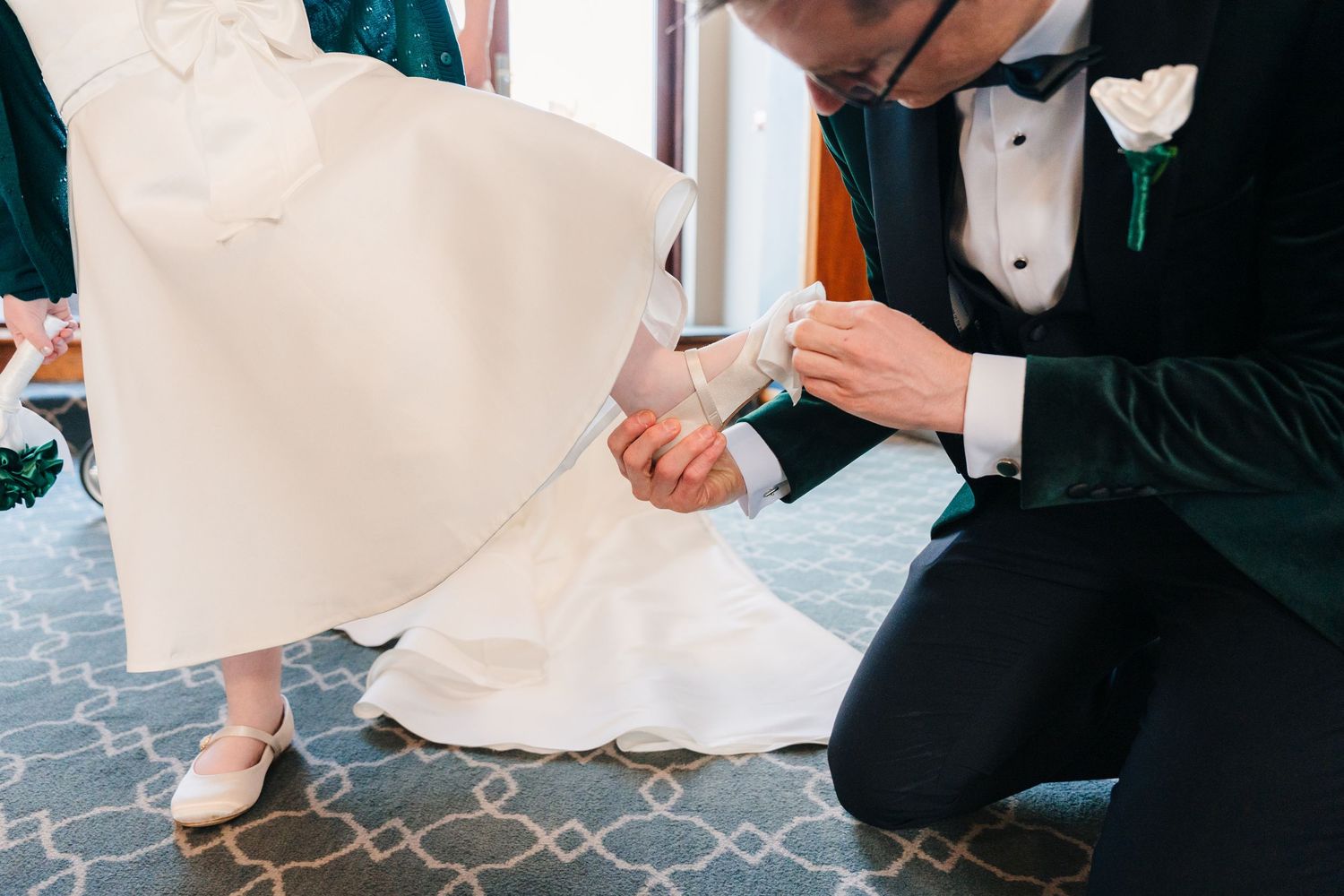 Bride in white dress and groom in tuxedo seen from waist down during formal ceremony.  Wedding PHOTOGRAPHER Trim Castle