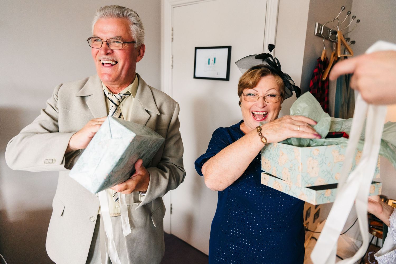 People laughing while holding gift boxes during a celebration. House Dublin Wedding Photographer